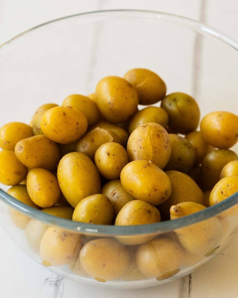 Cook the potatoes until the skins start to crack, or they are fork tender...