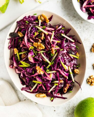 A colourful bowl of red cabbage and apple slaw, featuring thinly sliced red cabbage, crisp green apple strips, and walnuts, lightly dressed and ready to serve. Image by Jaz Kitchen