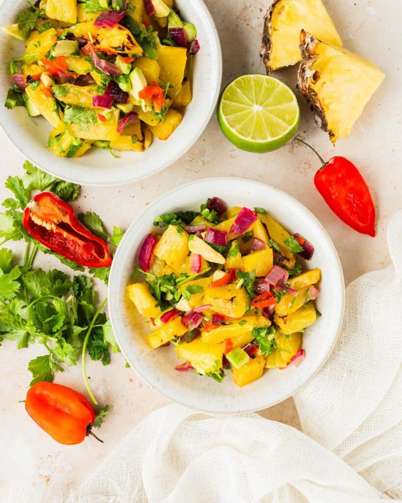 Flat lay image of two plates of pineapple habanero salsa.
