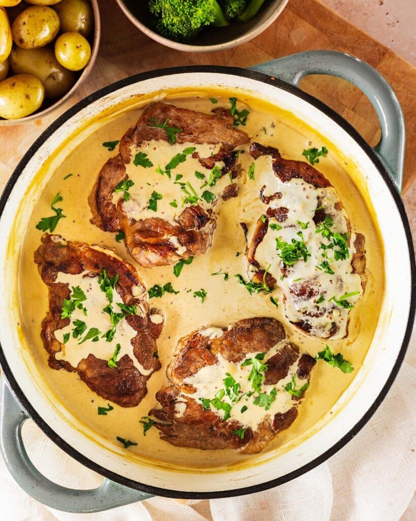 Creamy honey mustard pork steaks cooked in a pan. Image by Jaz Kitchen